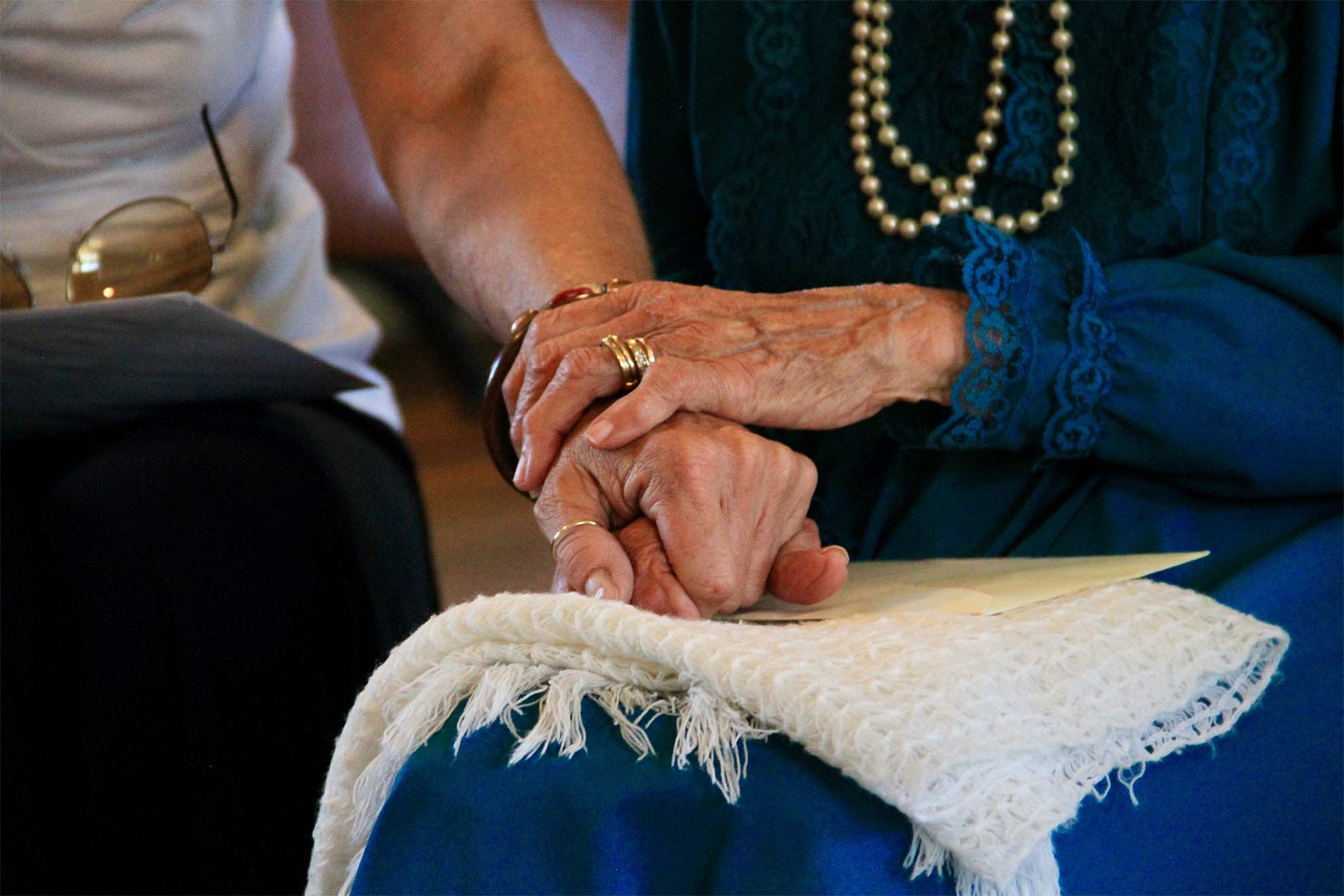 carer and resident holding hands