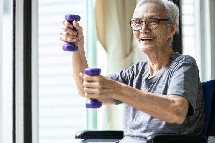 older woman in a wheelchair doing light exercise 