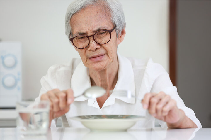 old woman eating but in state of confusion