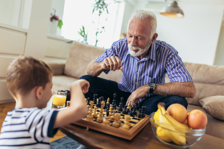 resident playing chess with child
