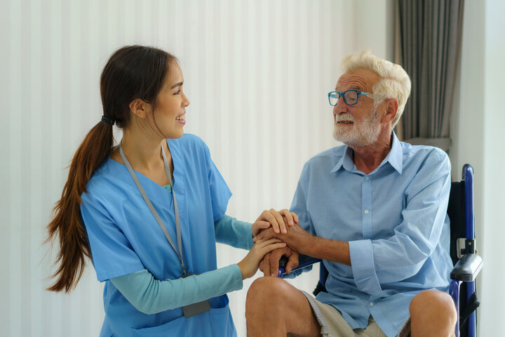 nurse comforting resident in wheelchair